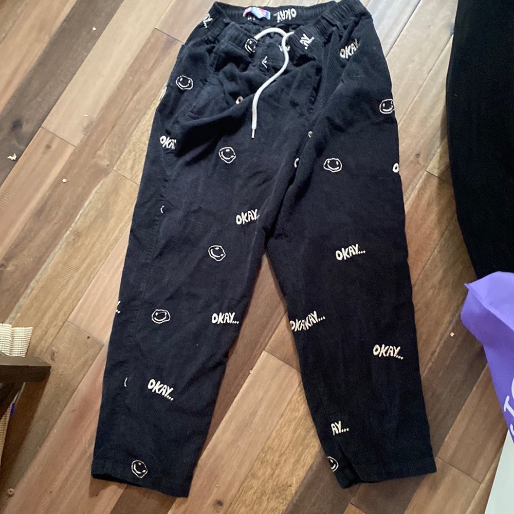 Black/Dark Blue Corduroy pants with smiley faces and “okay…” on them in white